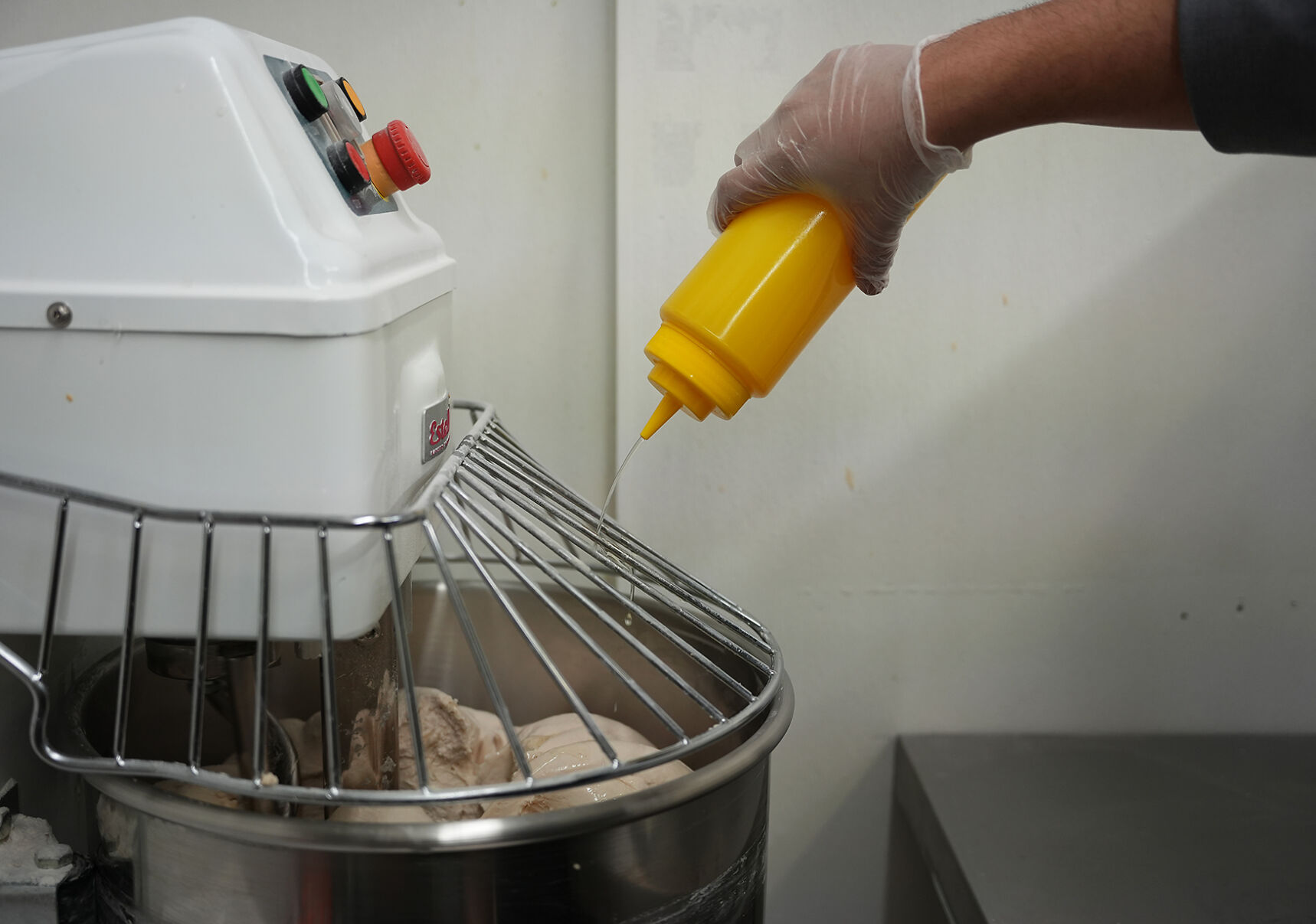 Ahmad Alkadah drizzles cooking oil onto pita dough